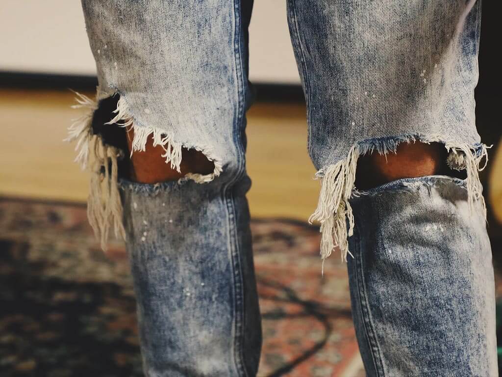 calça jeans desfiada nas pernas