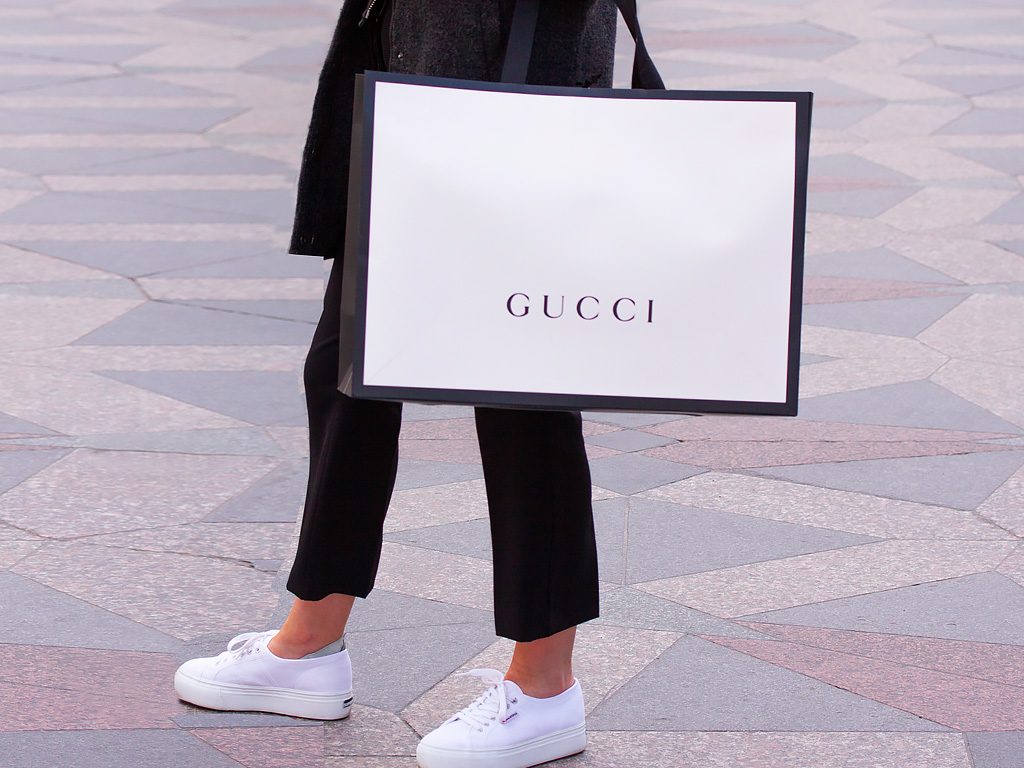 Mulher com uma sacola da Gucci