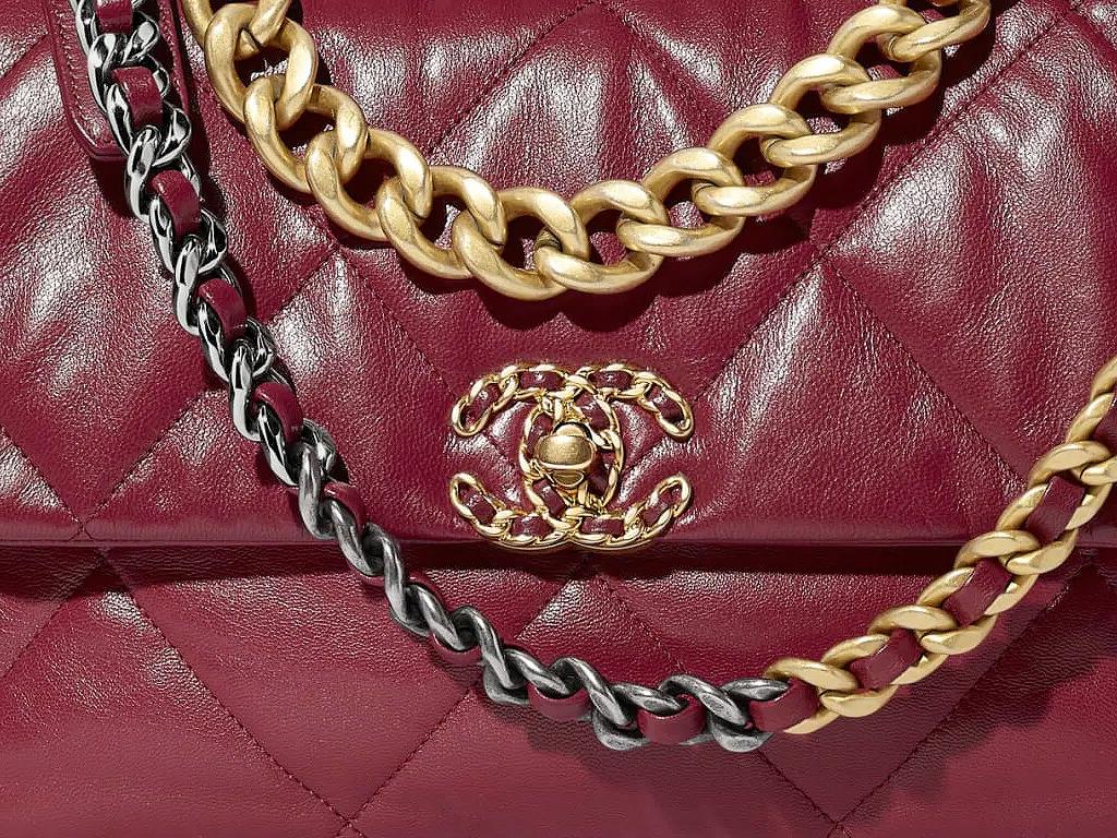 O modelo possui o clássico C duplo interligado da marca, além de alça em corrente em prateado e dourado, com couro entrelaçado.