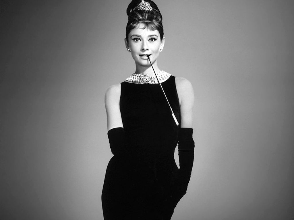 Audrey Hepburn usando vestido Chanel preto no filme "Bonequinha de luxo." Clique na imagem e confira mais vestidos Chanel!